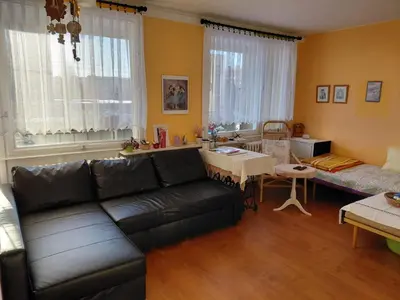 a living room with a black couch and a table at At the Star in Kladno