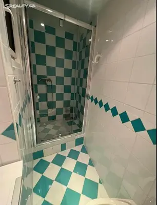a bathroom with a shower with a toilet and a tiled floor at Room for 2 in Central Prague 8 Apartment in Prague