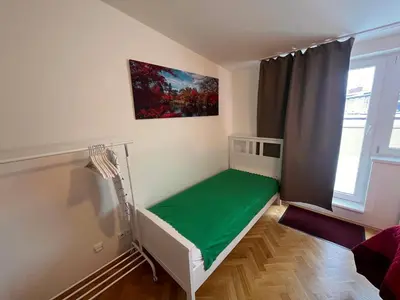 a bedroom with a bed and a green floor at Charming Apartment Klimentska in Prague