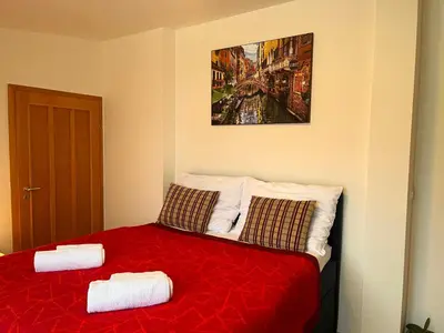 a bedroom with a red bed with two towels on it at Charming Apartment Klimentska in Prague