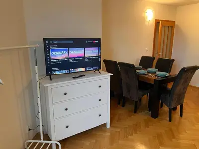 a dining room with a table and a television on a dresser at Charming Apartment Klimentska in Prague