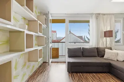 a living room with a couch and a large window at Apartment in a quiet part of Prague with a kitchen in Prague