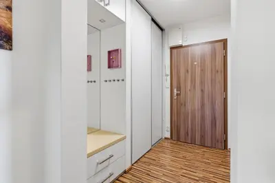 a hallway with white walls and a wooden door at Apartment in a quiet part of Prague with a kitchen in Prague