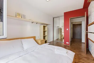 a bedroom with a white bed and a red wall at Apartment in a quiet part of Prague with a kitchen in Prague