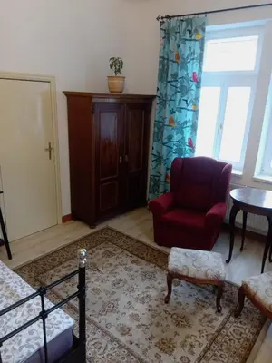 a living room with a red chair and a table at Historic Villa Apartments in Prague