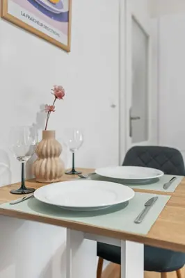 a table with two white plates and wine glasses at Boutique Loft Prague in Prague