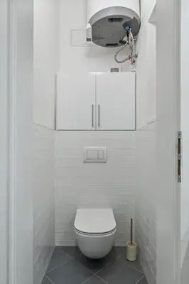 a white bathroom with a toilet and a spotlight at Boutique Loft Prague in Prague