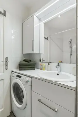 a white bathroom with a washing machine and a sink at Boutique Loft Prague in Prague
