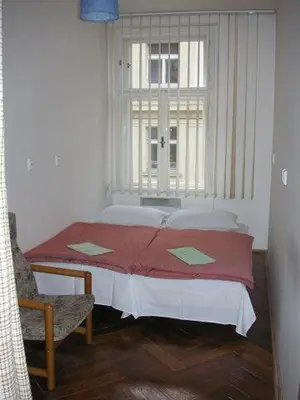 a small bedroom with a bed and a window at Hostel Bell in Prague