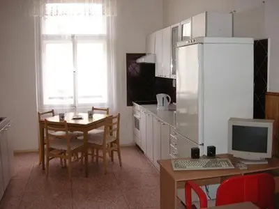 a kitchen with a table and a desk with a computer at Hostel Bell in Prague