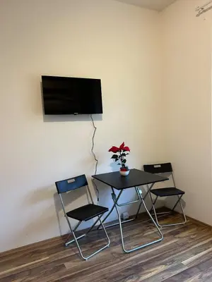 a table with two chairs and a tv on a wall at Bacpackers paradise in Prague City center in Prague