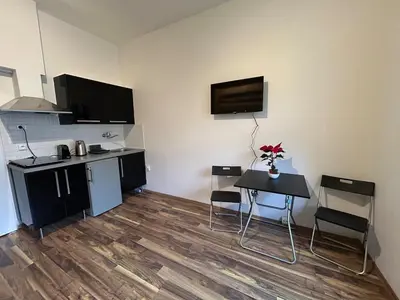 a kitchen with a table and a small table and chairs at Bacpackers paradise in Prague City center in Prague