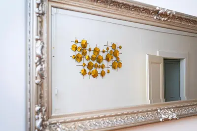 a mirror with a bunch of yellow birds on a wall at Victory Noble Estate in Prague