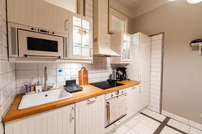 a kitchen with white cabinets and a sink at Charming Apartment in Haštalská in Prague