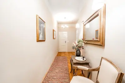 a hallway with a table and chairs and a mirror at Charming Apartment in Haštalská in Prague