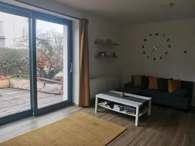 a living room with a couch and a sliding glass door at Large Apartment with terrace and big garden in Prague