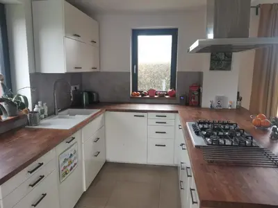 a kitchen with white cabinets and a stove top oven at Large Apartment with terrace and big garden in Prague