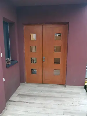 a pair of wooden doors in a room at Large Apartment with terrace and big garden in Prague