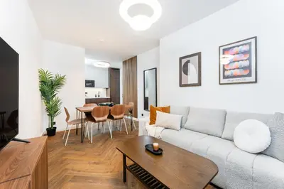 a living room with a couch and a table at Rentero Urban Elegance Suite - Prague 7 in Prague