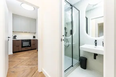 a bathroom with a glass shower and a sink at Rentero Urban Elegance Suite - Prague 7 in Prague