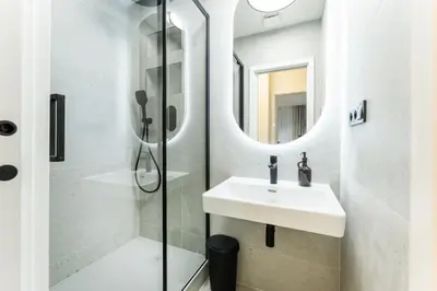 a bathroom with a sink and a shower at Rentero Urban Elegance Suite - Prague 7 in Prague