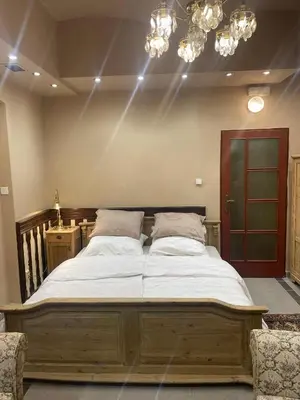 a large wooden bed in a bedroom with lights at Apartment Otakar in Nymburk