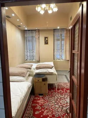 a bedroom with two beds and a red rug at Apartment Otakar in Nymburk