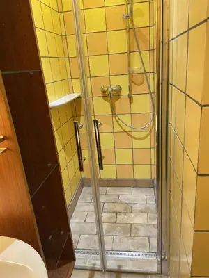 a bathroom with a shower and a tiled floor at Apartment Otakar in Nymburk