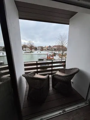 a balcony with two chairs and a view of the water at Retreat House Na návsi in Chotěšov