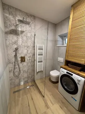 a bathroom with a shower and a washing machine at Retreat House Na návsi in Chotěšov
