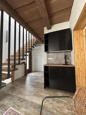 a living room with a television and a staircase at Retreat House Na návsi in Chotěšov
