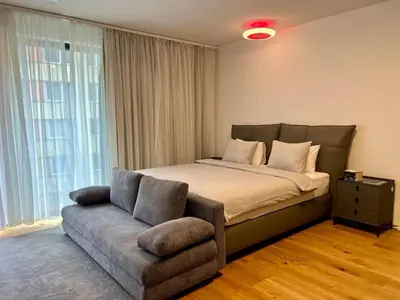 a bedroom with a large bed and a couch at Cozy Apartments in Prague