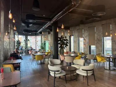 a restaurant with tables and chairs and people sitting at tables at Cozy Apartments in Prague