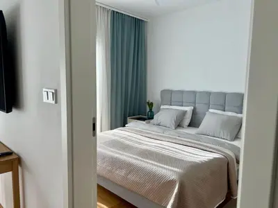 a bedroom with a bed and a couch and windows at Cozy Apartments in Prague