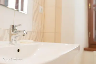 a bathroom with a white sink and a mirror at Huge 4 Rooms Charles Bridge Apartment in Prague