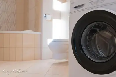 a washing machine in a bathroom with a toilet at Huge 4 Rooms Charles Bridge Apartment in Prague