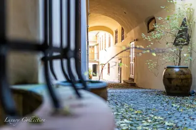 a row of benches in a hallway with a vase at Huge 4 Rooms Charles Bridge Apartment in Prague