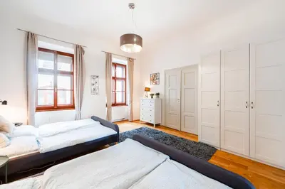 a bedroom with two beds and a table at Huge 4 Rooms Charles Bridge Apartment in Prague