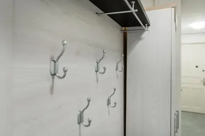 a row of hooks on a wall in a room at Rentero Smíchov Riverside & Station Residence in Prague