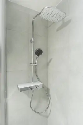 a shower with a shower head in a bathroom at Rentero Smíchov Riverside & Station Residence in Prague
