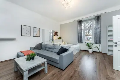 a living room with a couch and a table at Rentero Smíchov Riverside & Station Residence in Prague