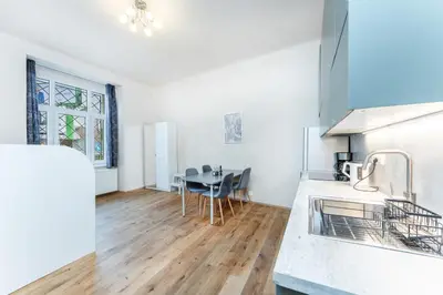 a kitchen with a table and a dining room at Rentero Smíchov Riverside & Station Residence in Prague