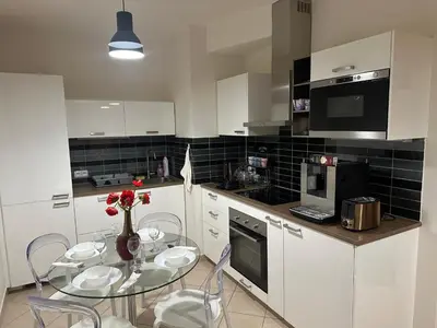 a kitchen with a table and chairs and a kitchen with white cabinets at Garden Residence - Byt 412 in Prague