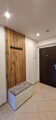 a room with a wooden wall with a bench next to a door at Garden Residence - Byt 412 in Prague