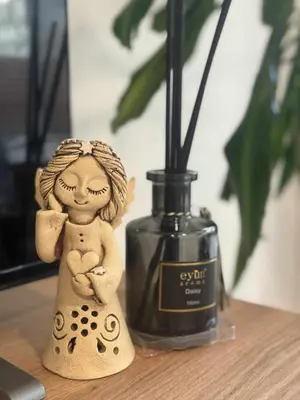 a small doll sitting next to a bottle of perfume at Garden Residence - Byt 412 in Prague