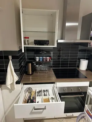 a kitchen with a white drawer and black tiles at Garden Residence - Byt 412 in Prague