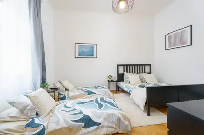 a bedroom with two beds and a desk at Quiet Apartment Near River and City Center in Prague