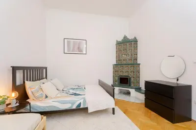 a bedroom with a bed and a dresser and a fireplace at Quiet Apartment Near River and City Center in Prague