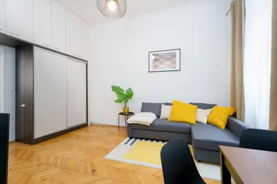 a living room with a blue couch and yellow pillows at Quiet Apartment Near River and City Center in Prague