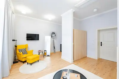 a living room with a yellow chair and a tv at Bohemia Boutique Hotel Prague in Prague